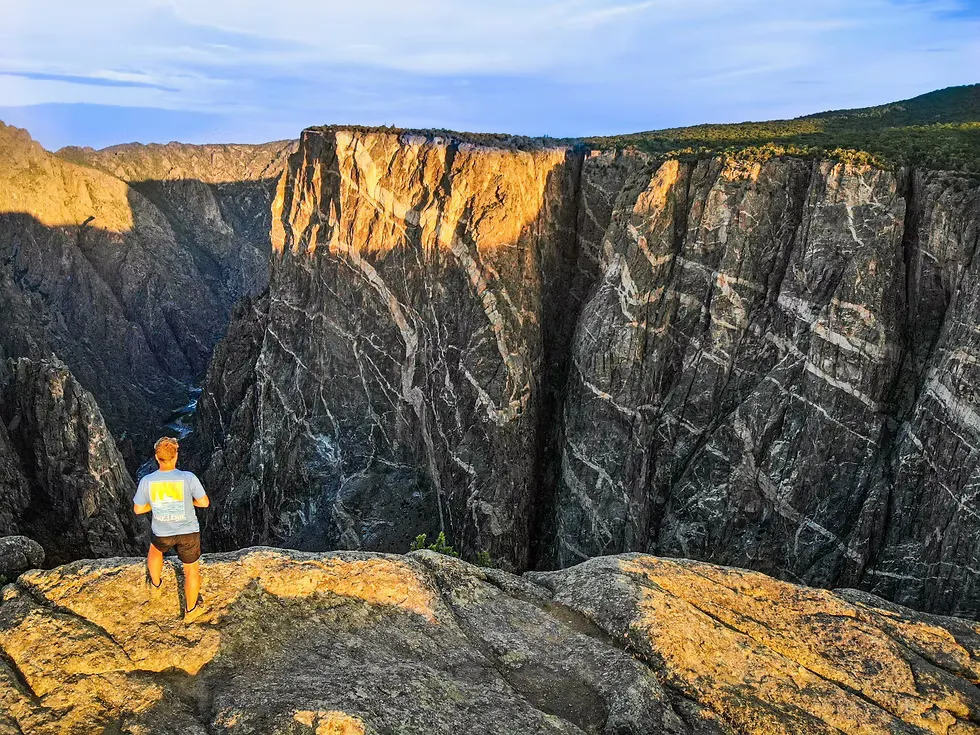 Visitors at the painted wall black canyon of the gunnison overlook with safety fencing and panoramic canyon views
